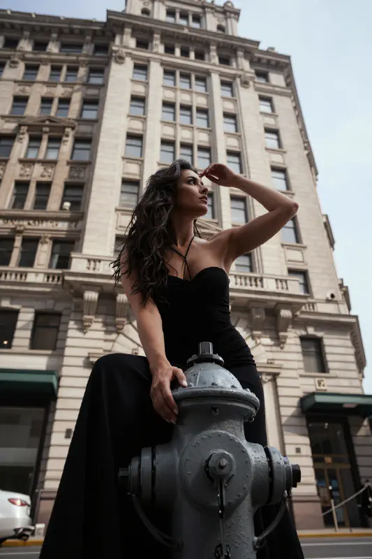 A Woman in Black Atop a Fire Hydrant